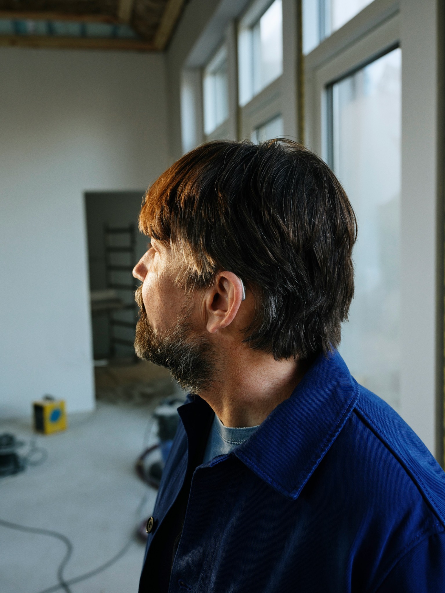 A man wearing a discreet hearing aid while working